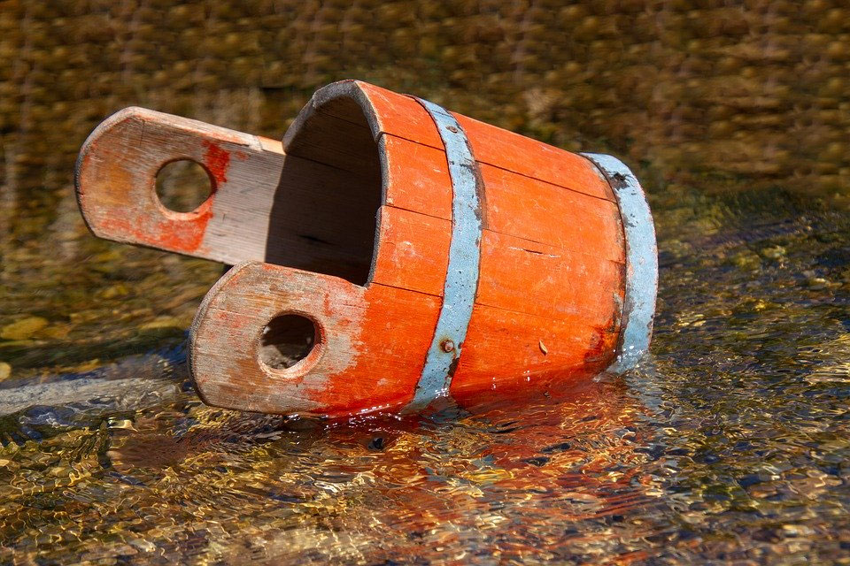 Kinder transportieren beim Wassertransport-Spiel Wasser zwischen Eimern